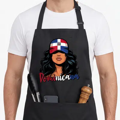 Proud dominican apron - Cartoon woman in red white blue flag cap with Dominicana script below — shown on a black cotton canvas apron against a white background