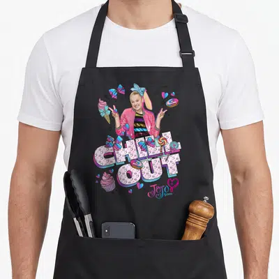 Funny chill apron - CHILL OUT text filled with hearts and stars surrounded by bows, lollipops, and cupcakes — shown on a black cotton canvas apron against a white background
