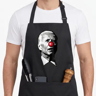 Show clown aprons - Grayscale man portrait with bright red clown nose printed on canvas — shown on a black cotton canvas apron against a white background