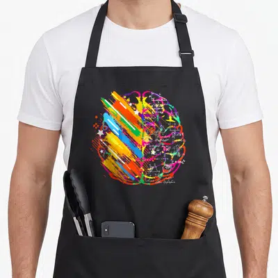 Brain painter apron - Stylized brain with paint strokes on one side and math equations including E=mc² on the other — shown on a black cotton canvas apron against a white background