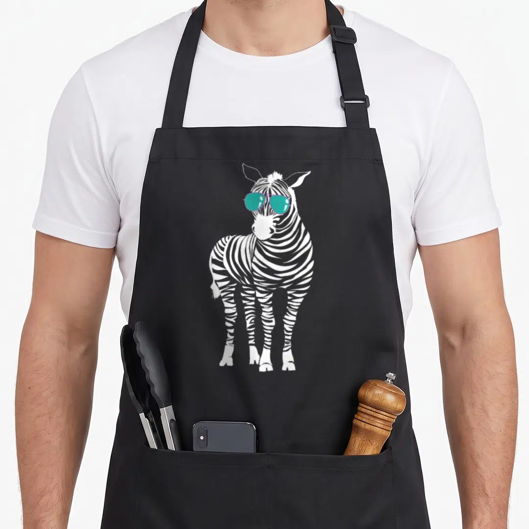 Sunglass zebra apron - White zebra illustration wearing teal aviator style glasses — shown on a black cotton canvas apron against a white background
