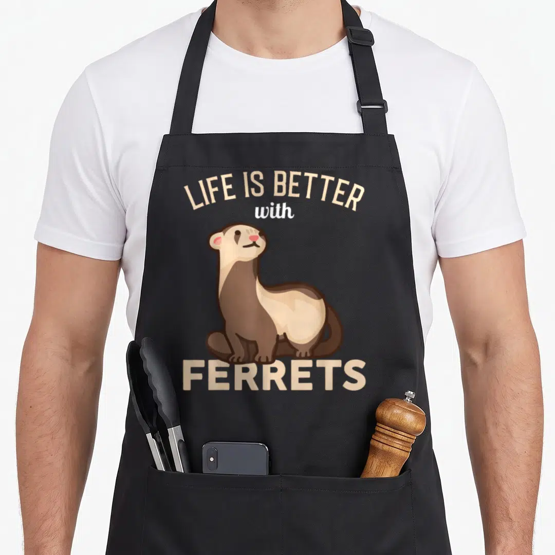 Better best ferret apron - Cartoon brown and white ferret with arched beige text LIFE IS BETTER WITH FERRETS — shown on a black cotton canvas apron against a white background