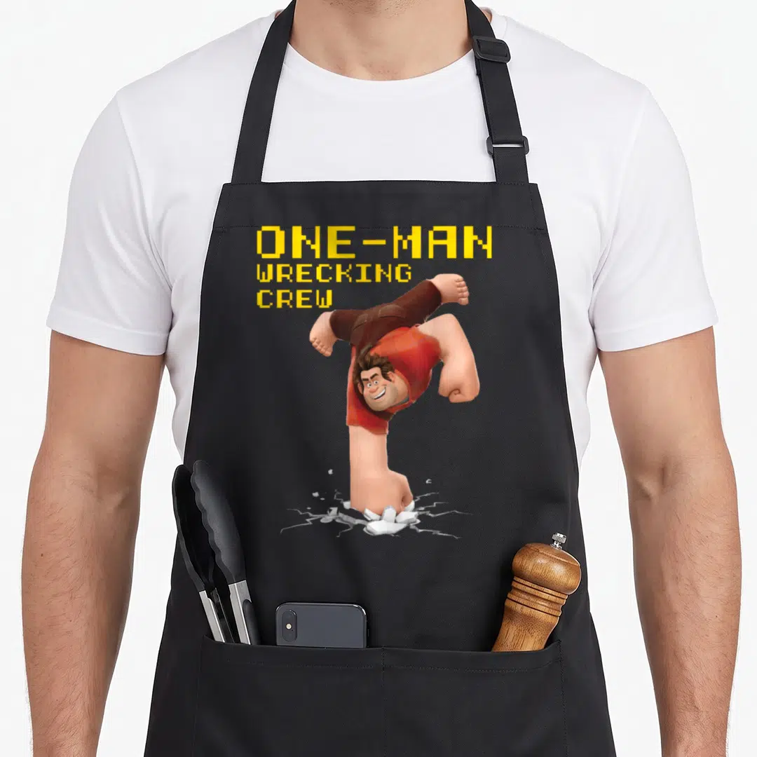 Wreck crew apron - Man bursting from ground below with ONE-MAN WRECKING CREY text in yellow pixel font — shown on a black cotton canvas apron against a white background