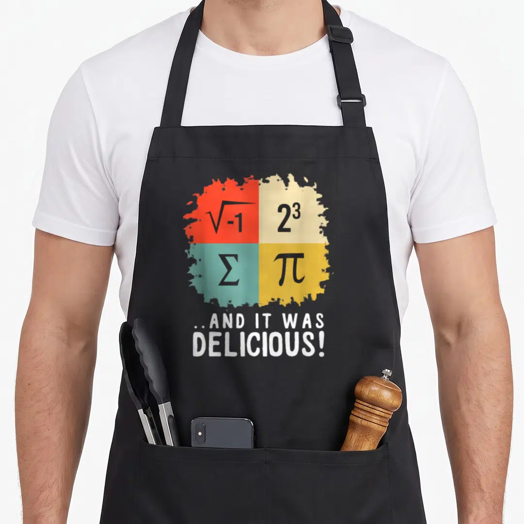 Math ottawa apron - Four math symbols in red beige teal yellow squares above white text..AND IT WAS DELICIOUS! — shown on a black cotton canvas apron against a white background