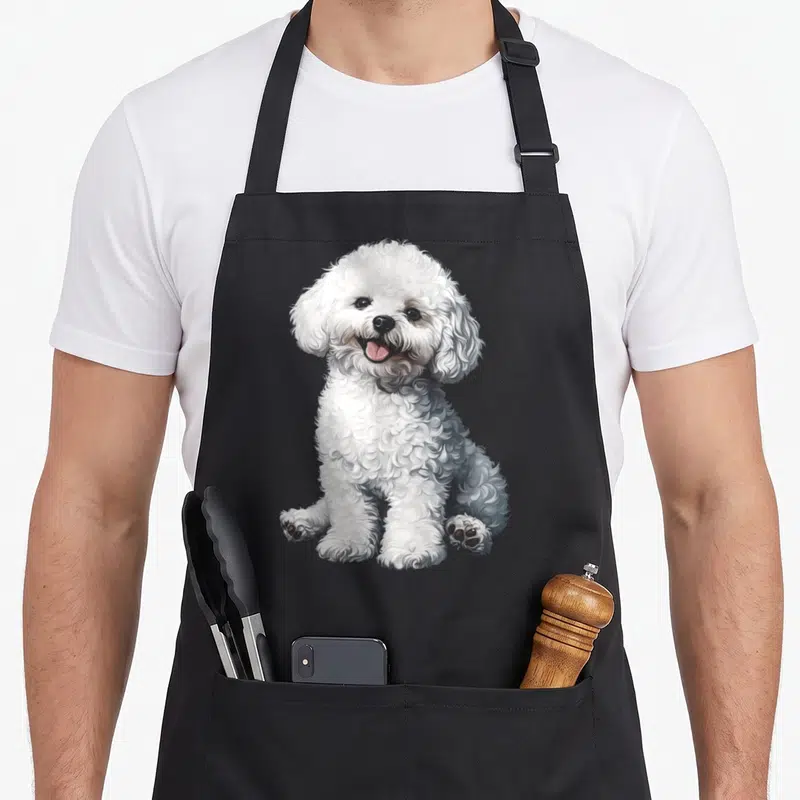 Frise motif dog apron - Realistic illustration of a sitting white curly-haired dog with grey shading — shown on a black cotton canvas apron against a white background