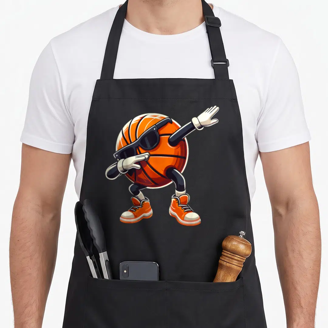 Basketball dabbing boys apron - Cartoon basketball character with sunglasses and sneakers in orange and black — shown on a black cotton canvas apron against a white background