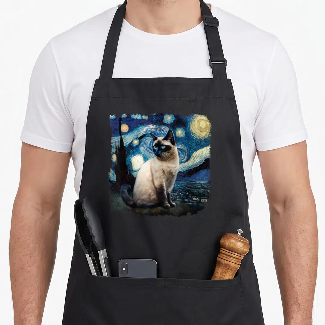 Van cute cat aprons - Realistic Siamese cat sitting before a swirling blue night sky with yellow stars and a dark — shown on a black cotton canvas apron against a white background