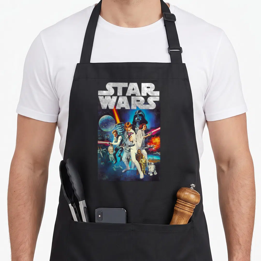 Hope distressed apron - STAR WARS logo above vintage photo montage of Luke Skywalker and space elements in blue and red — shown on a black cotton canvas apron against a white background