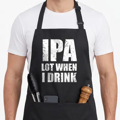 Drink drinking beer apron - White stacked text IPA LOT WHEN I DRINK on black bib apron — shown on a black cotton canvas apron against a white background