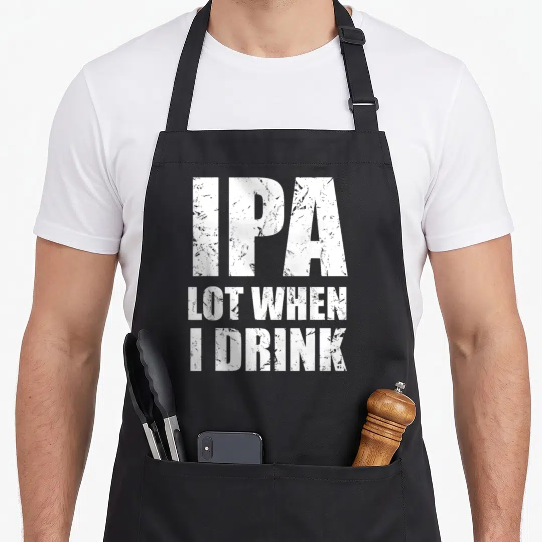 Drink drinking beer apron - White stacked text IPA LOT WHEN I DRINK on black bib apron — shown on a black cotton canvas apron against a white background