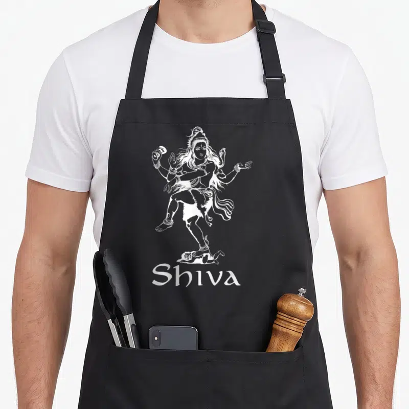 Gear diwali apron - White line art of Shiva dancing on a demon with centered Shiva text below — shown on a black cotton canvas apron against a white background