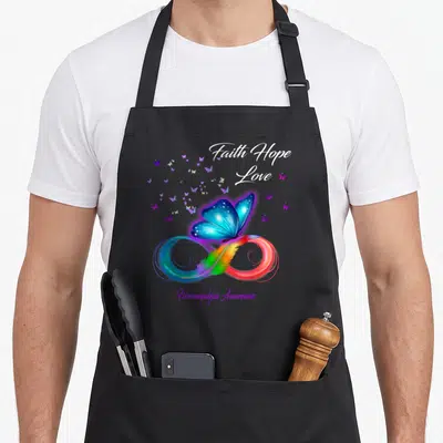 Hope butterfly apron - Blue butterfly on rainbow infinity symbol with Faith Hope Love text — shown on a black cotton canvas apron against a white background