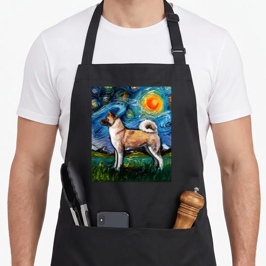 Inu starry dog apron - Akita dog standing on green grass under swirling blue sky and yellow sun — shown on a black cotton canvas apron against a white background