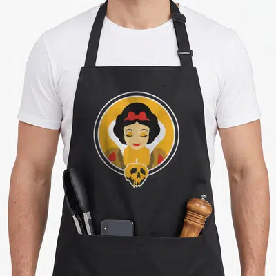 Poisoned apple apron - Minimalist Snow White in yellow circle above a black and yellow skull pumpkin — shown on a black cotton canvas apron against a white background