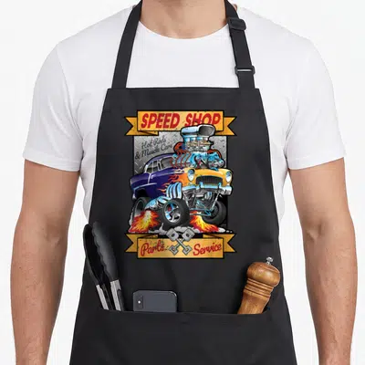 Speed cartoon apron - Blue and yellow hot rod with massive engine, crossed pistons, and speed shop text on yellow — shown on a black cotton canvas apron against a white background