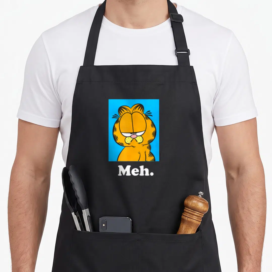 Meh midfielder apron - Orange Garfield face in blue square with white Meh text below — shown on a black cotton canvas apron against a white background
