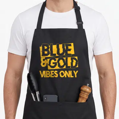 Blue game football apron - Stacked yellow and grey typography reading Blue and Gold Vibes Only on dark background — shown on a black cotton canvas apron against a white background
