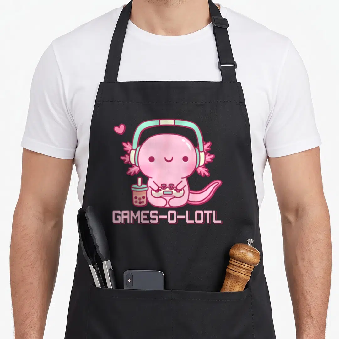 Gamesolotl kawaii cooking apron - Pink axolotl with mint headphones holding controller next to bubble tea — shown on a black cotton canvas apron against a white background