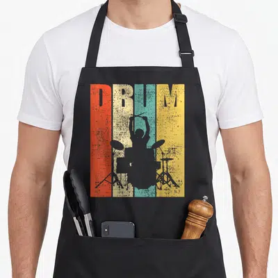 Drummer pigeon forge apron - Grey drummer silhouette over red beige teal and yellow stripes with DRUM text — shown on a black cotton canvas apron against a white background