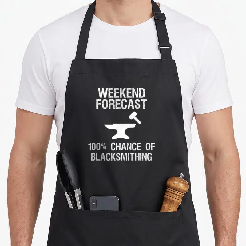 Blacksmithing blacksmith apron - White distressed text weekend forecast 100% chance of blacksmithing with anvil — shown on a black cotton canvas apron against a white background