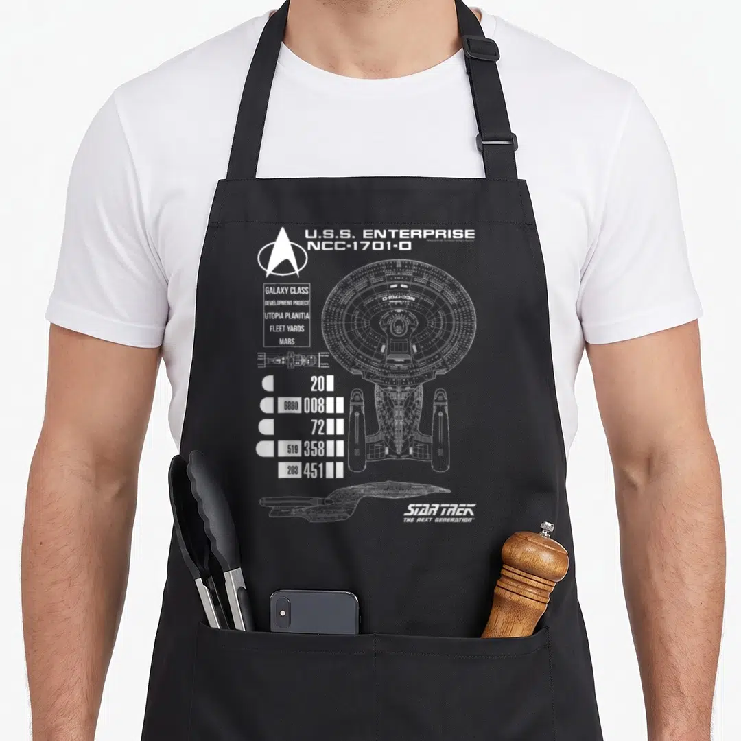 Generation star apron - White line-art blueprint of the U.S.S. Enterprise NCC-1701-D with technical data — shown on a black cotton canvas apron against a white background