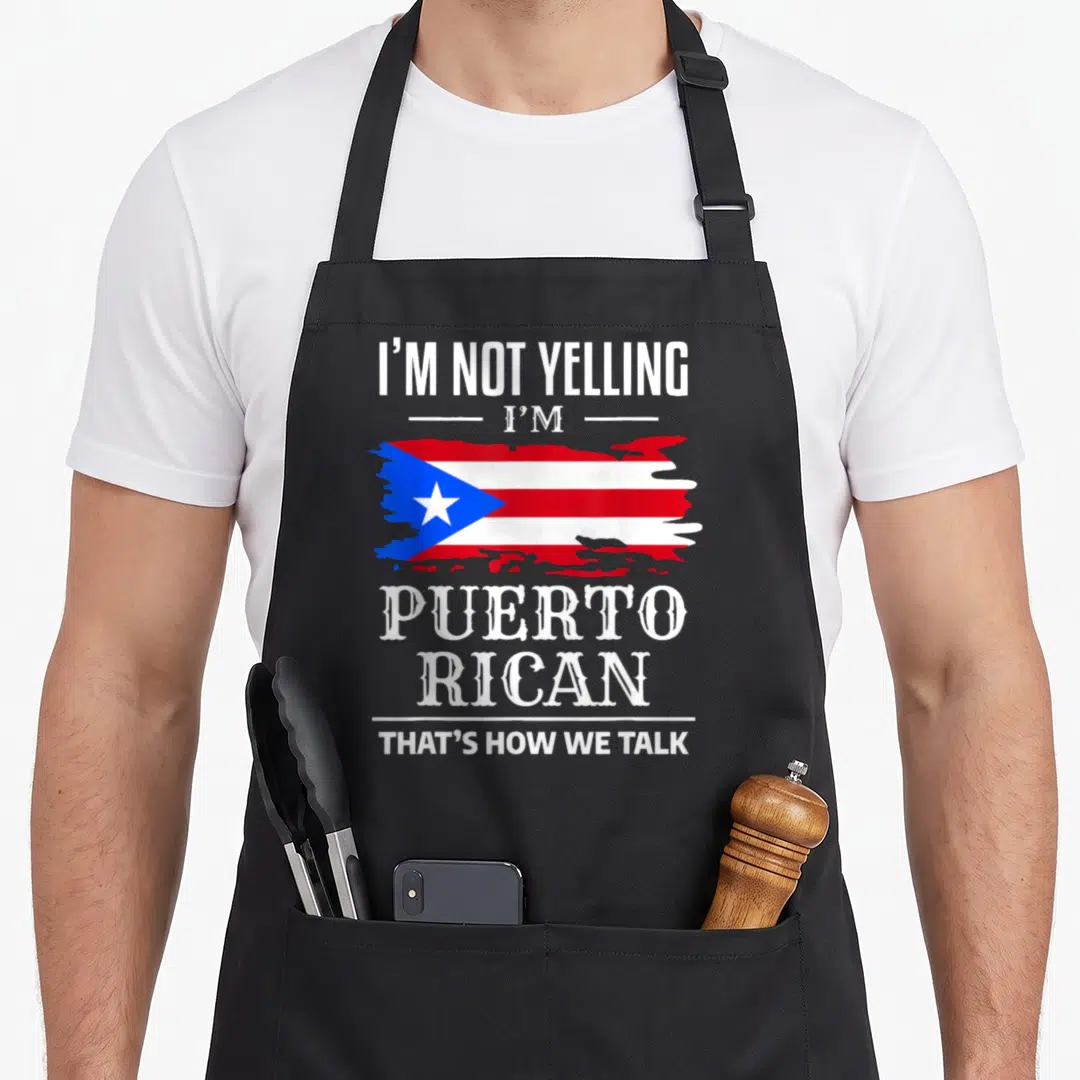 Rican rico pride apron - I'm Not Yelling Puerto Rican flag text stacked vertically in red white blue — shown on a black cotton canvas apron against a white background