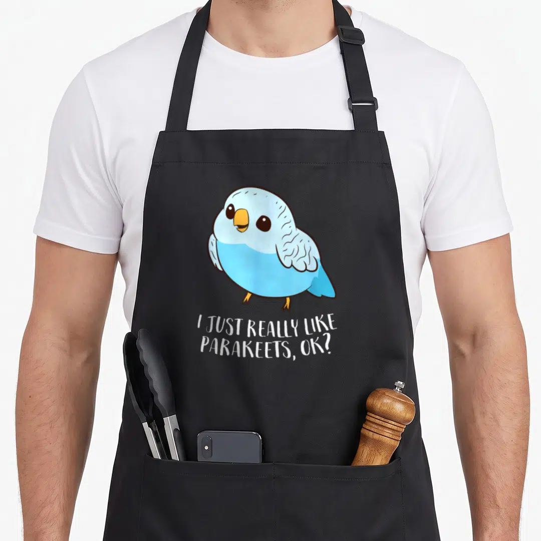 Funny parakeet bird apron - Cartoon blue parakeet above white text reading I just really like parakeets ok — shown on a black cotton canvas apron against a white background