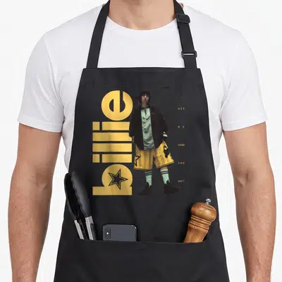 Hit hard apron - Billie Eilish photo with yellow billie text and HIT ME HARD AND SOFT words — shown on a black cotton canvas apron against a white background