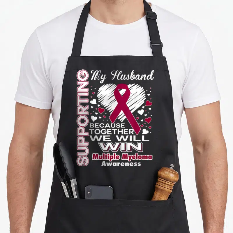 Myeloma husband apron - Maroon ribbon over white sketched heart with supportive text about Multiple Myeloma — shown on a black cotton canvas apron against a white background