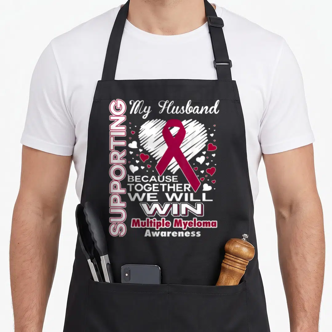 Myeloma husband apron - Maroon ribbon over white sketched heart with supportive text about Multiple Myeloma — shown on a black cotton canvas apron against a white background