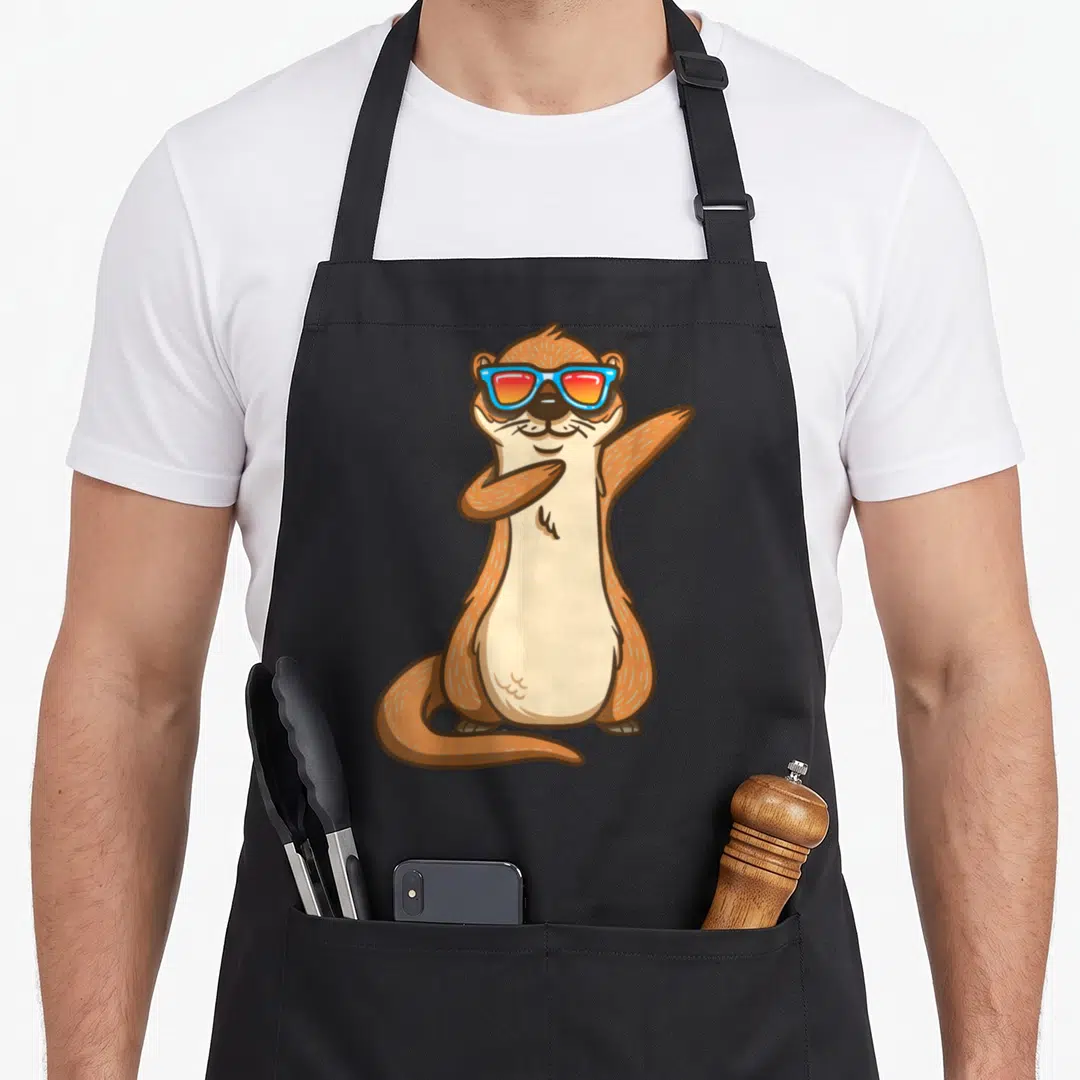 Kindergarten animal apron - Cartoon brown otter dabbing in blue and red sunglasses standing on hind legs — shown on a black cotton canvas apron against a white background