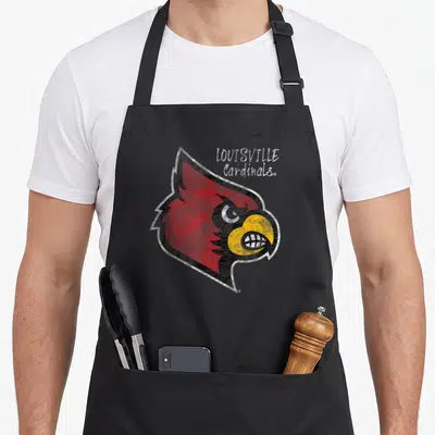 Cahoot cardinal apron - Distressed red cardinal head with LOUISVILLE Cardinals text stacked in corner — shown on a black cotton canvas apron against a white background