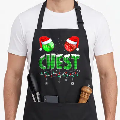 Couple family christmas aprons - CHEST in green plaid with snow, two Santa-hat ornaments, and Christmas lights — shown on a black cotton canvas apron against a white background