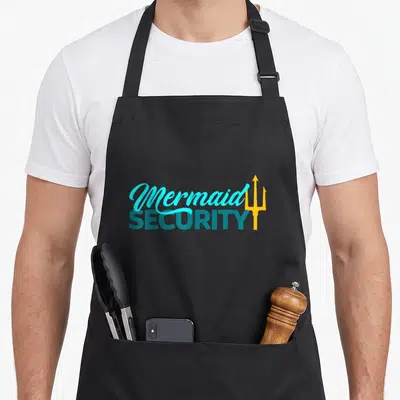 Mermaid security birthday apron - Stacked Mermaid SECURITY text with yellow trident in cyan and teal — shown on a black cotton canvas apron against a white background