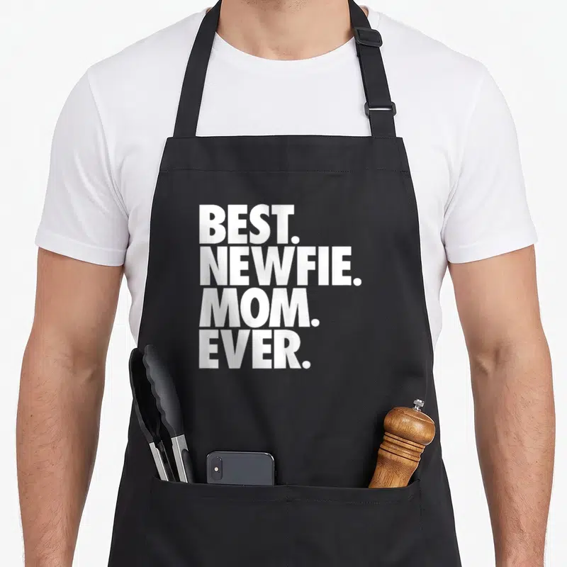 Newfie newfoundland dog apron - Stacked white text BEST. NEWFIE. MOM. EVER. on black background — shown on a black cotton canvas apron against a white background