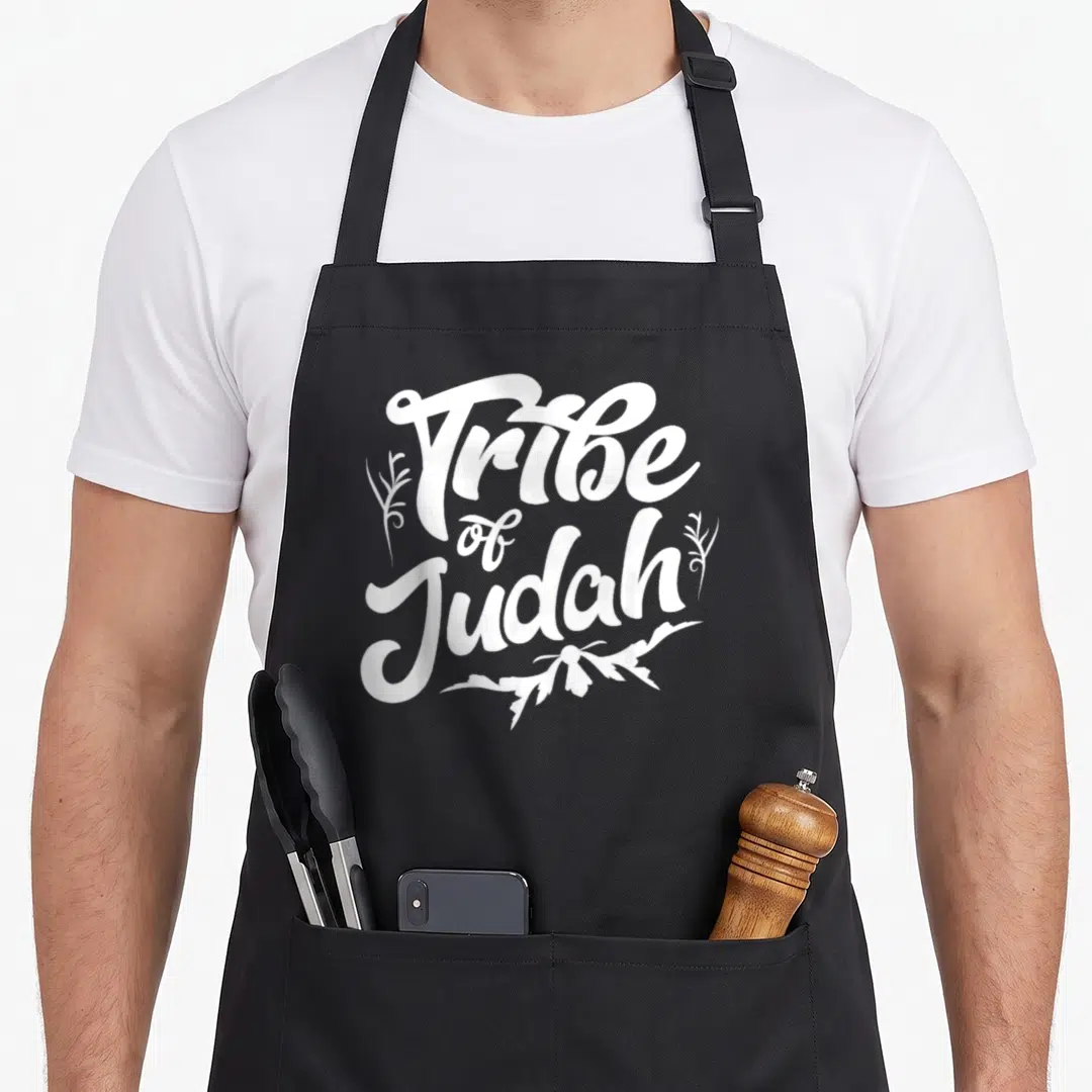 Israelite lion apron - White stacked text Tribe of Judah surrounded by decorative leafy branches — shown on a black cotton canvas apron against a white background