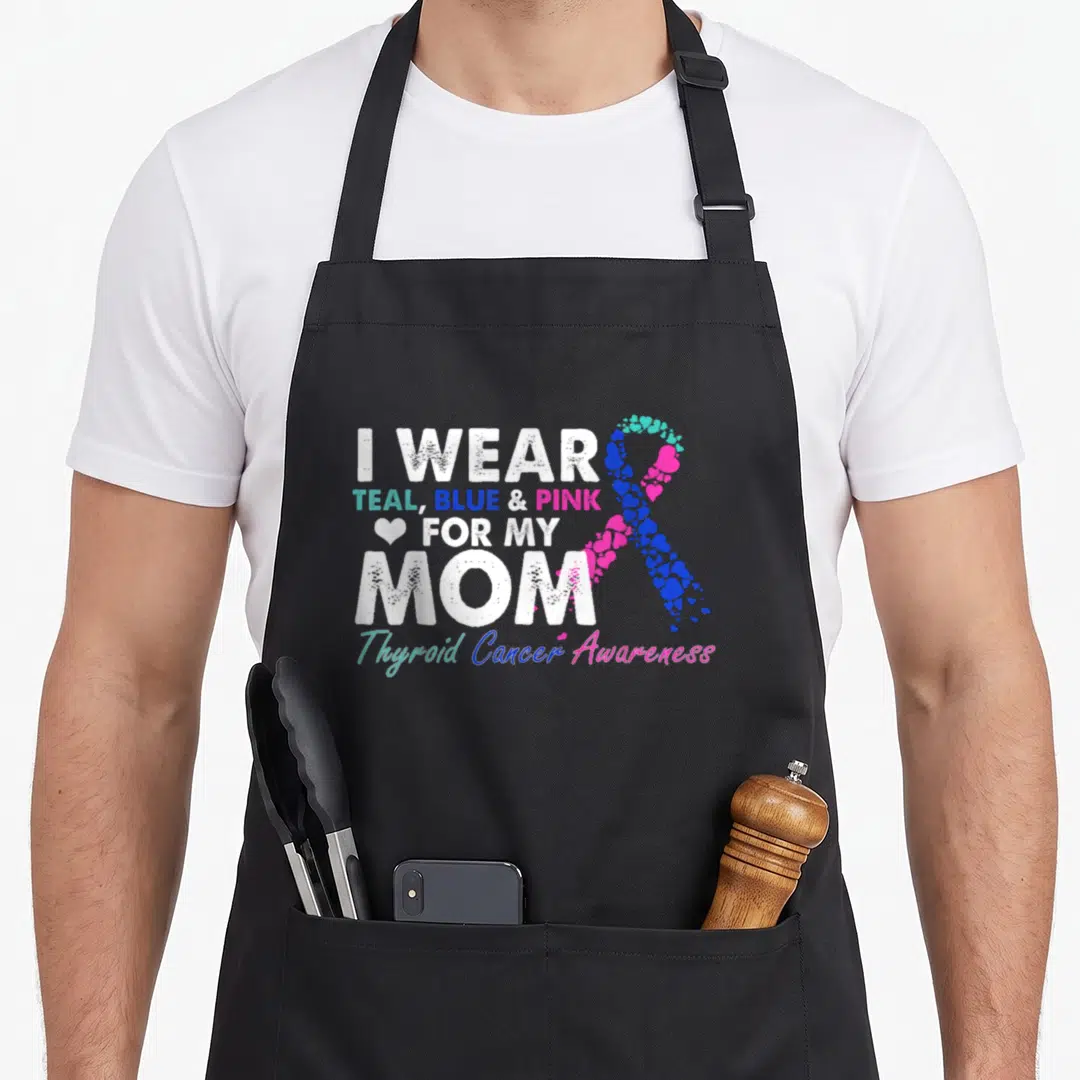 Costume thyroid apron - Stacked text I WEAR TEAL BLUE PINK FOR MY MOM with heart ribbon — shown on a black cotton canvas apron against a white background