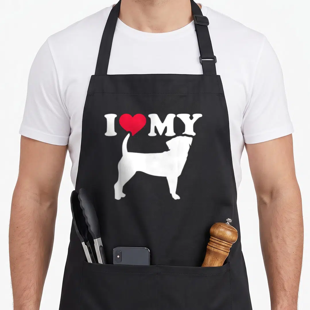 Retro puggle apron - White dog silhouette below I MY text and red heart — shown on a black cotton canvas apron against a white background