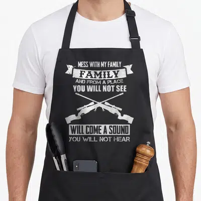 Mess family aprons - White distressed text Mess With My Family above two crossed sniper rifles — shown on a black cotton canvas apron against a white background