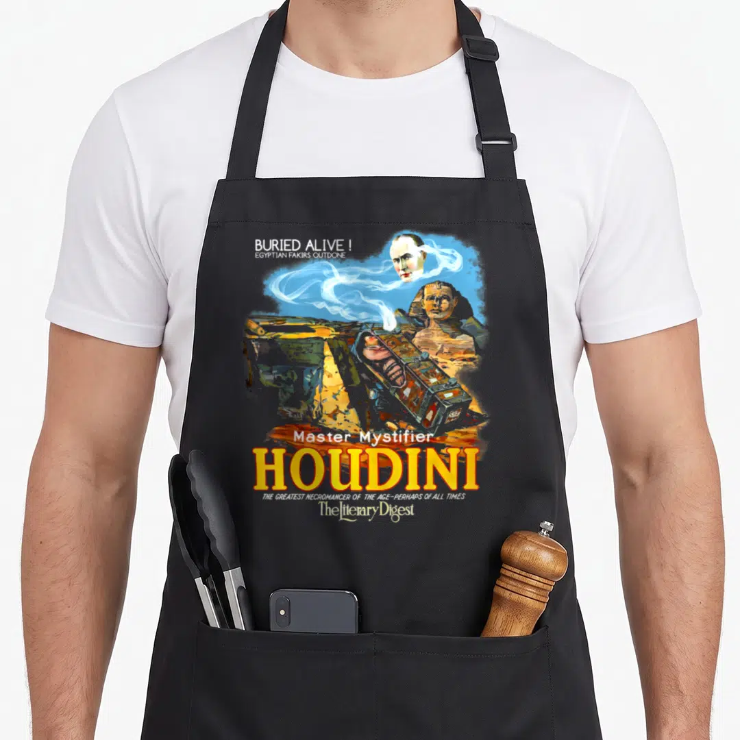 Houdini magic apron - Vintage Houdini poster with sarcophagus, Sphinx, floating head, and Buried Alive text in yellow — shown on a black cotton canvas apron against a white background