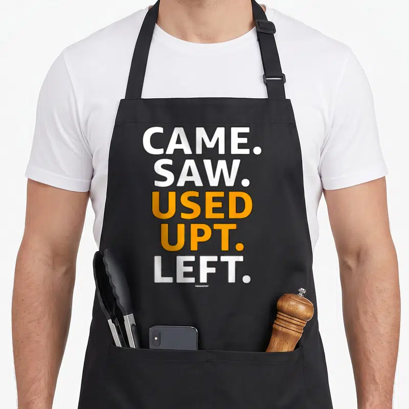Saw left apron - Stacked white and orange text reading CAME. SAW. USED UPT. LEFT — shown on a black cotton canvas apron against a white background