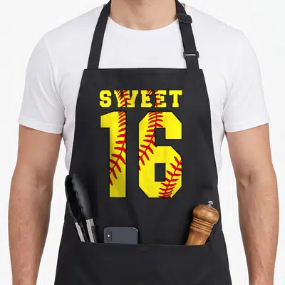 Softball sweet sixteen apron - Yellow SWEET 16 text with red baseball stitching pattern — shown on a black cotton canvas apron against a white background
