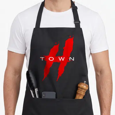 Hustle texas apron - Red H-shaped blood splatter with white TOWN text across center — shown on a black cotton canvas apron against a white background