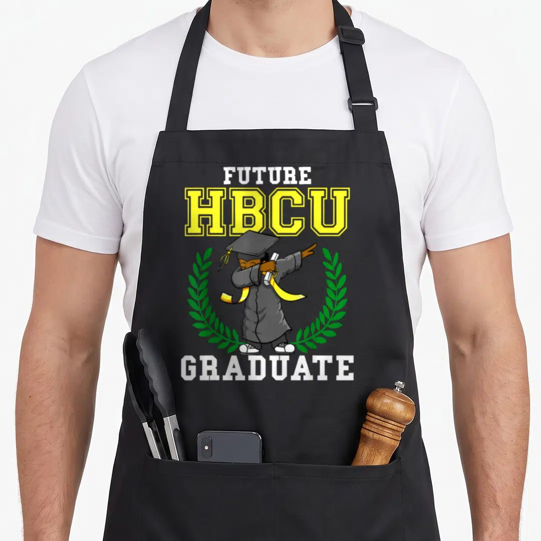 Future dabbing boys apron - Cartoon graduate dabbing between FUTURE HBCU GRADUATE text and green wreath — shown on a black cotton canvas apron against a white background