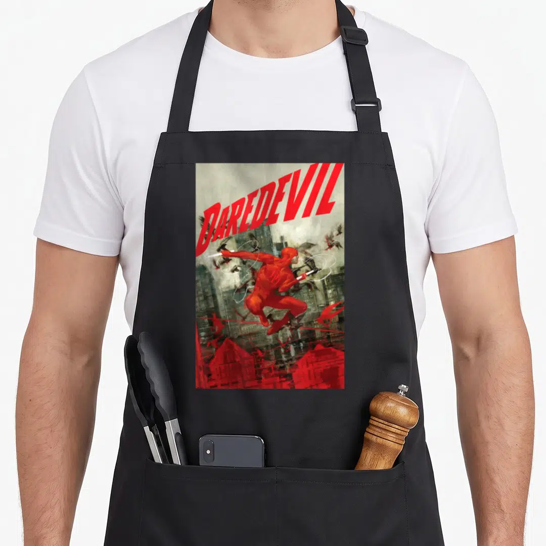 Comixology cover apron - DAREDEVIL text red figure leaping grey city scene scattered birds realistic art — shown on a black cotton canvas apron against a white background
