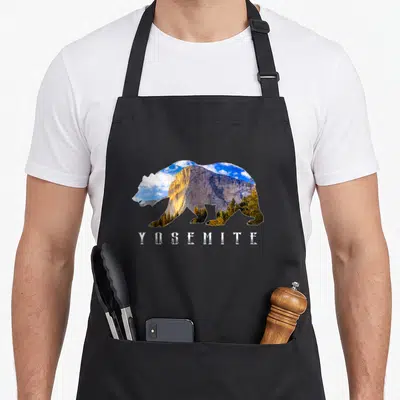 Yosemite bear apron - Bear silhouette filled with landscape photo and YOSEMITE text below — shown on a black cotton canvas apron against a white background