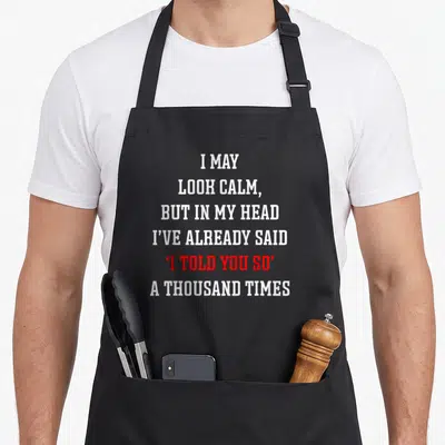 Funny may apron - Stacked white and red text reading I told you so sarcasm quote — shown on a black cotton canvas apron against a white background