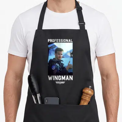 Gun professional apron - Pilot photo with PROFESSIONAL WINGMAN text and TOP GUN logo in grey white blue — shown on a black cotton canvas apron against a white background