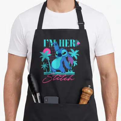 Stitch couple apron - Retro blue Stitch character with I'M HER text and cyan palm trees on pink grid — shown on a black cotton canvas apron against a white background