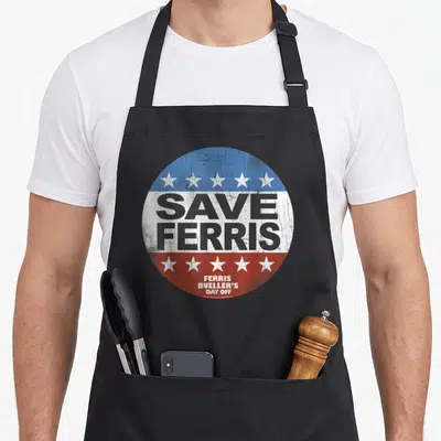 Bueller ferry apron - Distressed circular campaign button with Save Ferris text, blue white red bands, and five white — shown on a black cotton canvas apron against a white background